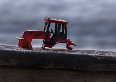 tractor, juguete, miniatura, rojo, madera, textura, fondo desenfocado, objeto, nostalgia, campo, agricultura, maqueta, detalle, exterior, invierno, frío, composición, fotografía creativa, contraste, soledad.