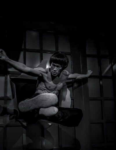 artista marcial, artes marciales, acción, patada, movimiento, figura, blanco y negro, monocromo, contraste, sombra, luz dramática, fuerza, energía, combate, entrenamiento, cine, escena, postura, cuerpo, dinamismo, intensidad, fondo oscuro, composición artística, fotografía creativa, expresión.