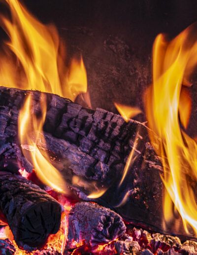 chimenea, fuego, llamas, brasas, calor, leña, madera, invierno, hogar, confort, acogedor, combustión, energía, fuego doméstico, textura, naranja, rojo, amarillo, llama, ceniza, calor humano, ambiente cálido, rusticidad, chimenea tradicional, detalle, madera quemada, relajación, interior, noche, bienestar