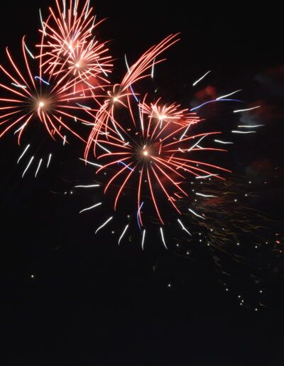 fuegos artificiales, celebración, fiesta, espectáculo, noche, explosión, colores, rojo, blanco, luz, festividad, pirotecnia, energía, alegría, evento, brillo, tradición, celebración nocturna, fotografía nocturna, larga exposición, movimiento, destellos, cielo oscuro, diversión, festival, entretenimiento, colorido, emoción, evento público, vacaciones