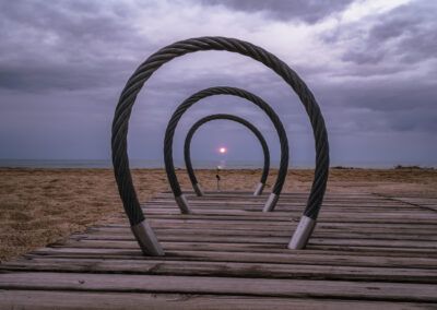 escultura, aros, círculos, playa, mar, pasarela de madera, perspectiva, simetría, sol, horizonte, instalación artística, arte urbano, geometría, rosa blanca, composición, costa, minimalismo, profundidad, fotografía conceptual, paisaje marino.