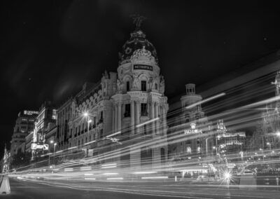 Madrid, edificio Metrópolis, Gran Vía, noche, larga exposición, estelas de luz, tráfico, arquitectura, blanco y negro, fotografía urbana, ciudad, movimiento, iluminación nocturna, monumento, paisaje urbano.