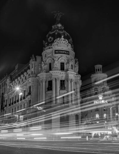 Madrid, edificio Metrópolis, Gran Vía, noche, larga exposición, estelas de luz, tráfico, arquitectura, blanco y negro, fotografía urbana, ciudad, movimiento, iluminación nocturna, monumento, paisaje urbano.