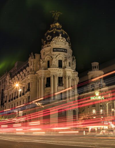 Madrid, edificio Metrópolis, Gran Vía, larga exposición, luces rojas, tráfico nocturno, arquitectura histórica, ciudad, noche, paisaje urbano, movimiento, centro de Madrid, turismo, iluminación, velocidad.