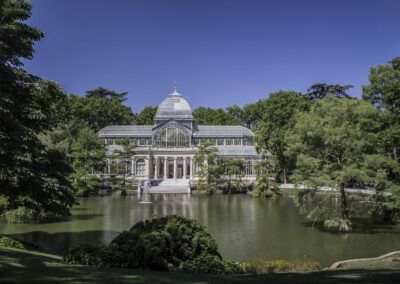 Palacio de Cristal, parque del Retiro, Madrid, estanque, reflejo, vegetación, cielo azul, arquitectura de cristal, parque, naturaleza, turismo, monumento, paisaje urbano, jardín, patrimonio.