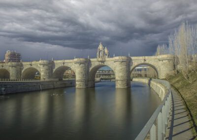 Puente de Toledo, Madrid, puente, arquitectura histórica, monumento, río Manzanares, arcos, piedra, patrimonio, paisaje urbano, larga exposición, agua, reflejos, cielo dramático, nubes, ciudad, turismo, arquitectura española, fotografía de viaje, panorama.