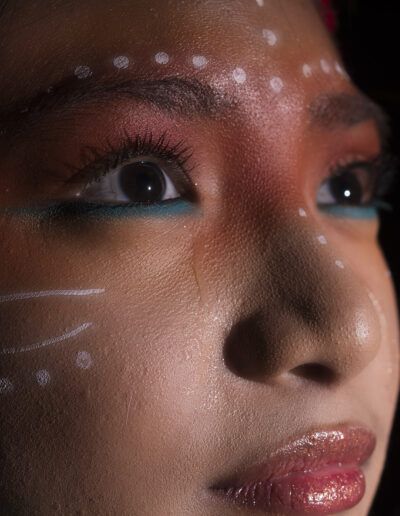 ojos, mirada, primer plano, perfil, maquillaje, pintura facial, rostro, detalle, luz, pestañas, labios, retrato, fondo negro, expresión, fotografía artística.