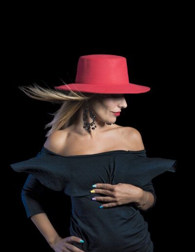 mujer, vestido negro, sombrero rojo, moda, retrato, fondo negro, pose, glamour, elegancia, hombros descubiertos, accesorios, labios rojos, contraste, estudio, fotografía artística.