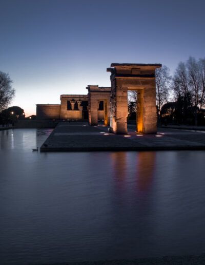 Templo de Debod, Madrid, crepúsculo, anochecer, monumento egipcio, iluminación, reflejo, agua, arquitectura, paisaje nocturno, árboles, larga exposición, turismo, patrimonio, cielo azul.