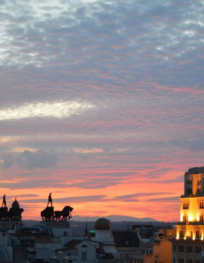 Madrid, atardecer, cielo rosado, cuadrigas, tejados, siluetas, edificio iluminado, paisaje urbano, hora azul, nubes, arquitectura, horizonte, ciudad, luces, fotografía urbana.