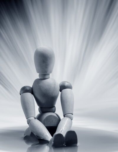 maniquí de madera, figura articulada, soledad, reflexión, minimalismo, blanco y negro, fondo abstracto, luz, quietud, melancolía, objeto, composición conceptual, superficie reflectante, fotografía artística, silencio.